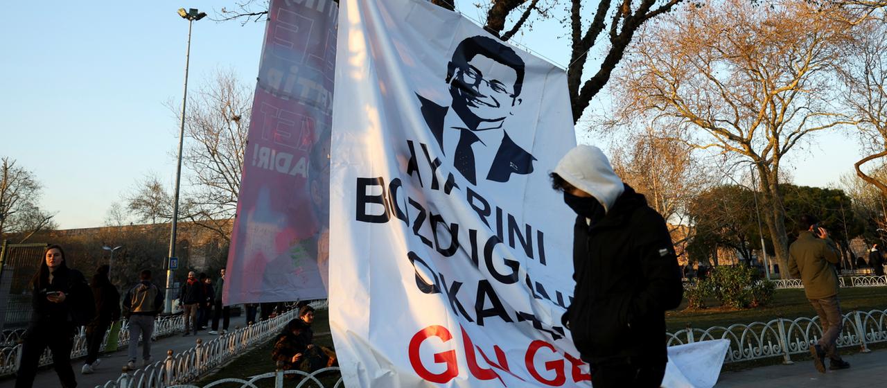 Ein Demonstrant in Istanbul geht an einem Banner mit dem Bild des inhaftierten Istanbuler Bürgermeisters Ekrem İmamoğlu vorbei.
