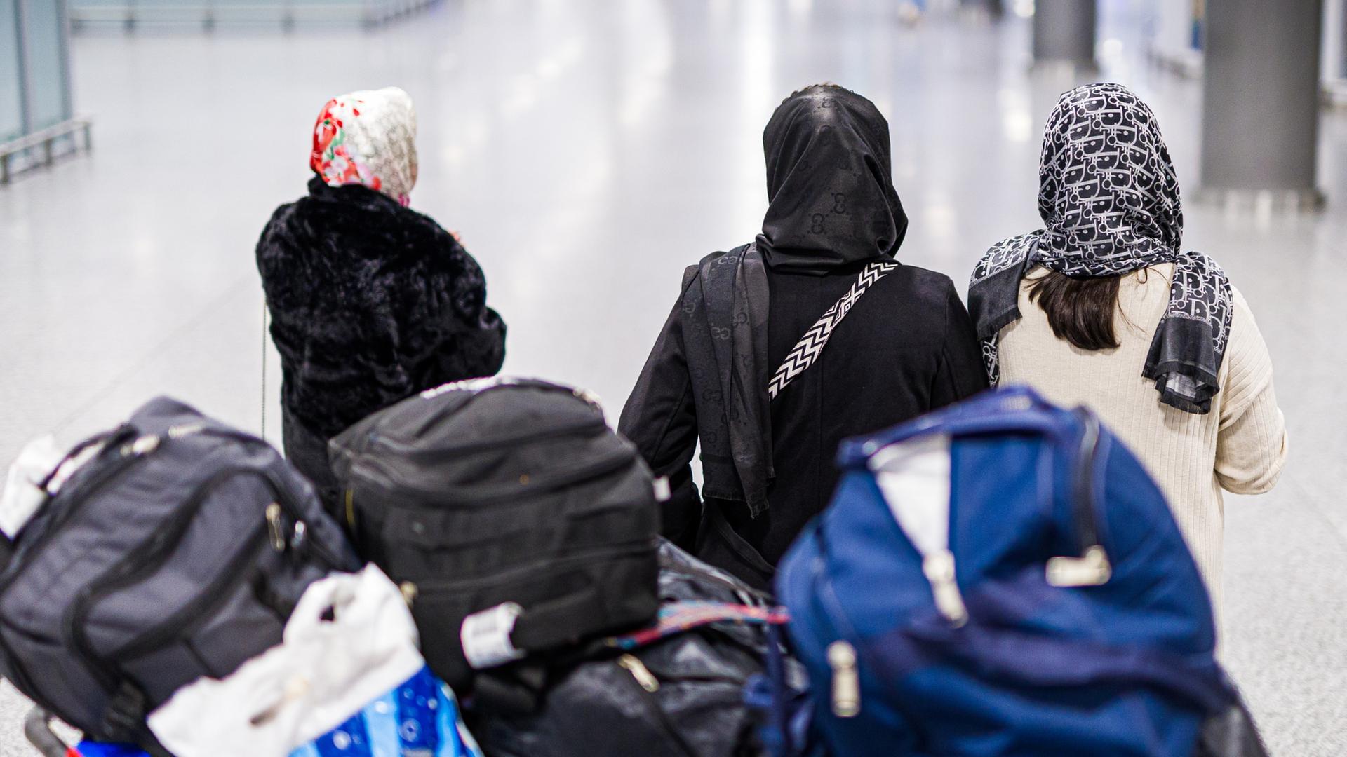 Menschen aus Afghanistan warten mit ihrem Gepäck im Flughafen Hannover-Langenhagen | dpa