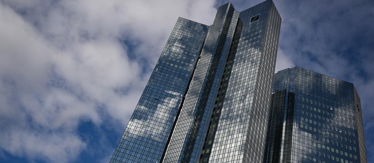 Wolken spiegeln sich in der gläsernen Fassade der Zentrale der Deutschen Bank in Frankfurt