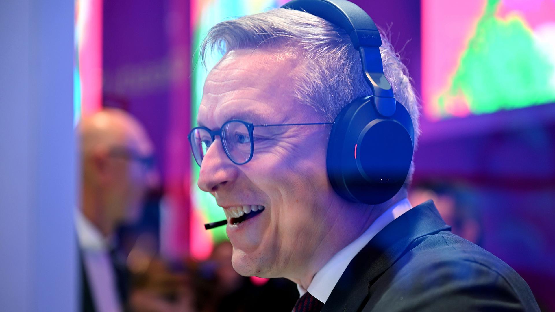 Karsten Wildberger spricht auf der MWC mithilfe eines Headsets mit K�nstlicher Intelligenz. | Wolf von Dewitz/dpa