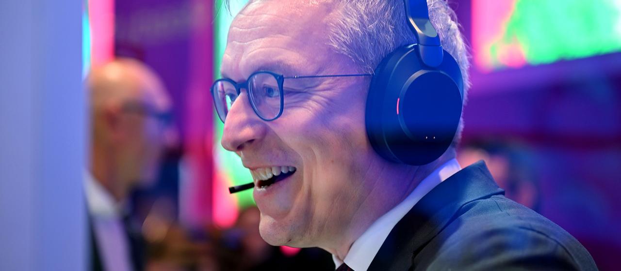 Karsten Wildberger spricht auf der MWC mithilfe eines Headsets mit Künstlicher Intelligenz.