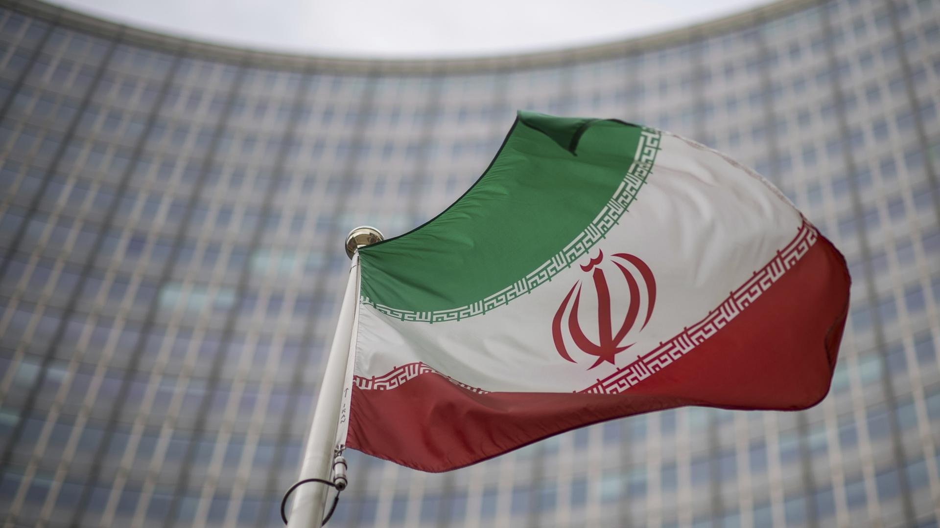 Eine iranische Nationalflagge weht vor dem Gebäude der Internationalen Atomenergiebehörde | dpa