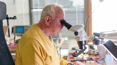 Ein Senior arbeitet in seiner Elektronik-Werkstatt. 