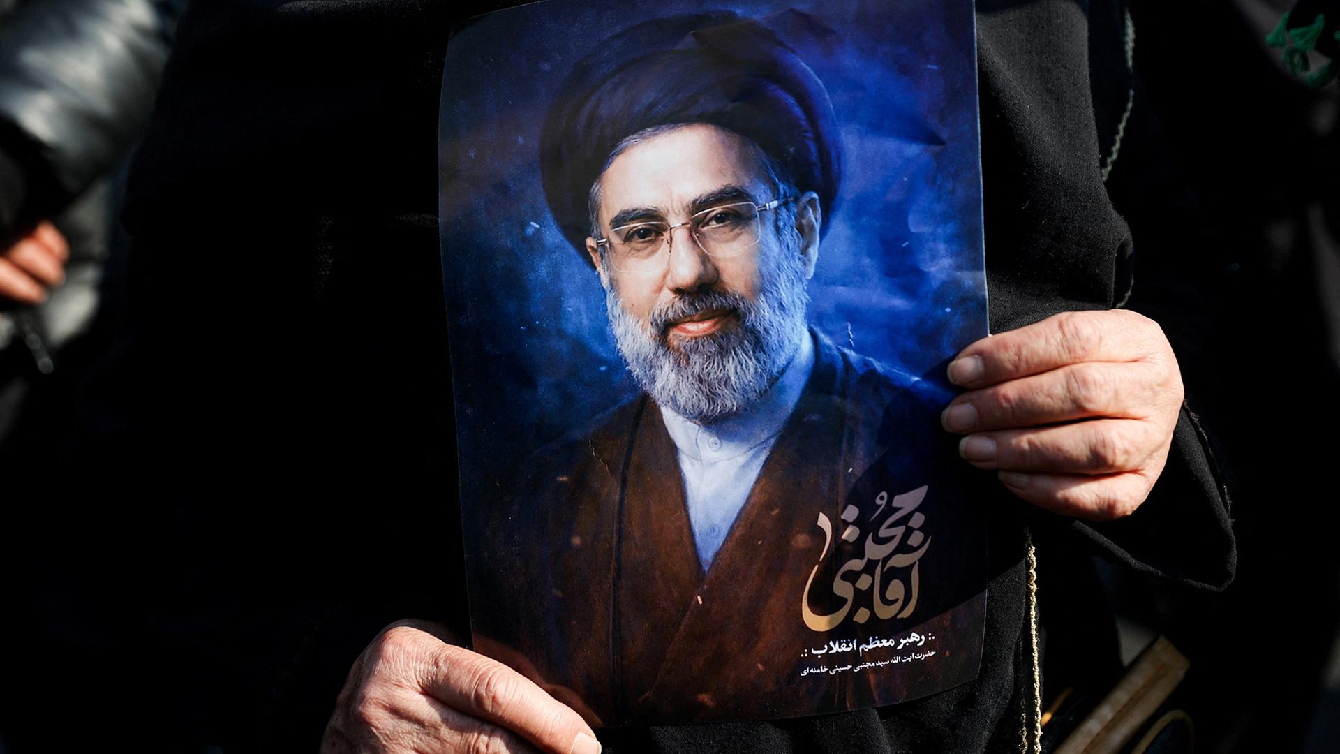 Eine Frau hält ein Bild von Modschtaba Chamenei in den Händen. | Majid Asgaripour/WANA (West Asia News Agency) via REUTERS