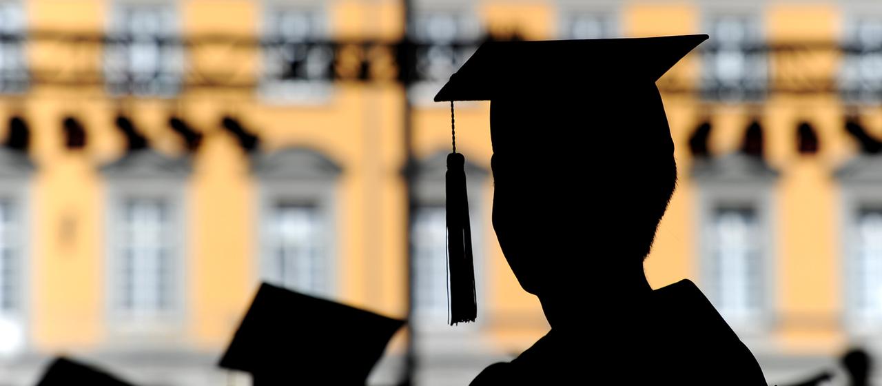 Absolventen der Rheinischen Friedrich-Wilhelms-Universität in Bonn feiern auf dem Campus in Talare gekleidet ihren Abschluss.