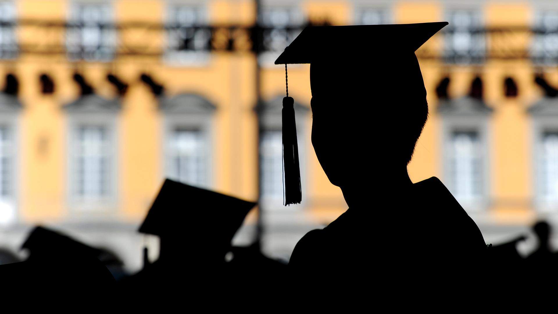 Absolventen der Rheinischen Friedrich-Wilhelms-Universität in Bonn feiern auf dem Campus in Talare gekleidet ihren Abschluss. | picture alliance/dpa
