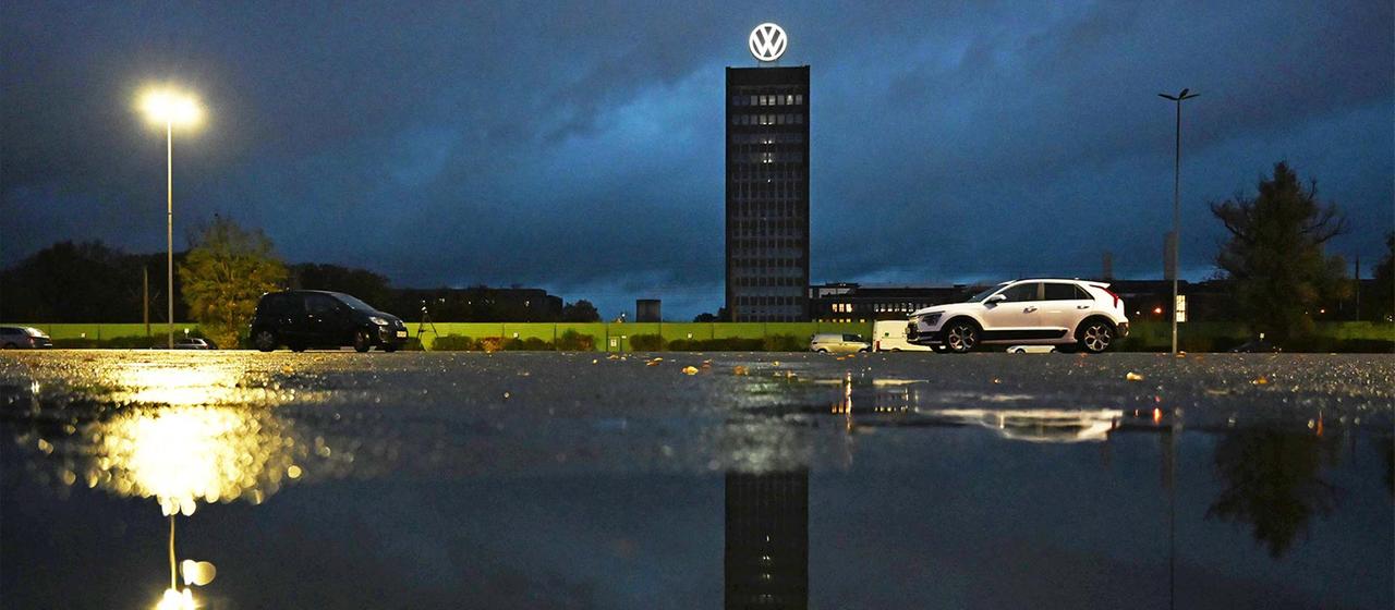 Das VW-Logo leuchtet auf dem Markenhochhaus auf dem Gelände vom VW Stammwerk.