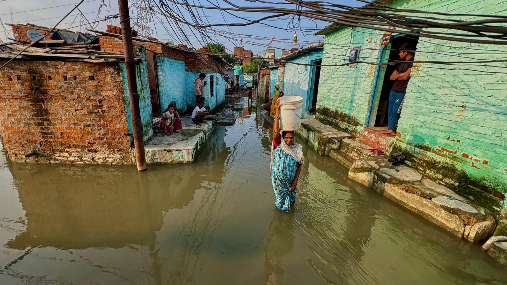 Eine Frau watet in Kanpur (Indien) durch das Hochwasser in ihrer Nachbarschaft. (Archivbild: 22.09.2026) | AP Photo/