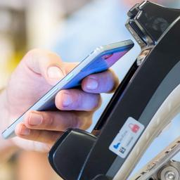 Ein Smartphone wird an einen Bezahl-Terminal gehalten.