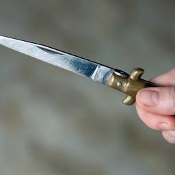 Eine Hand hält ein spitzes Messer.