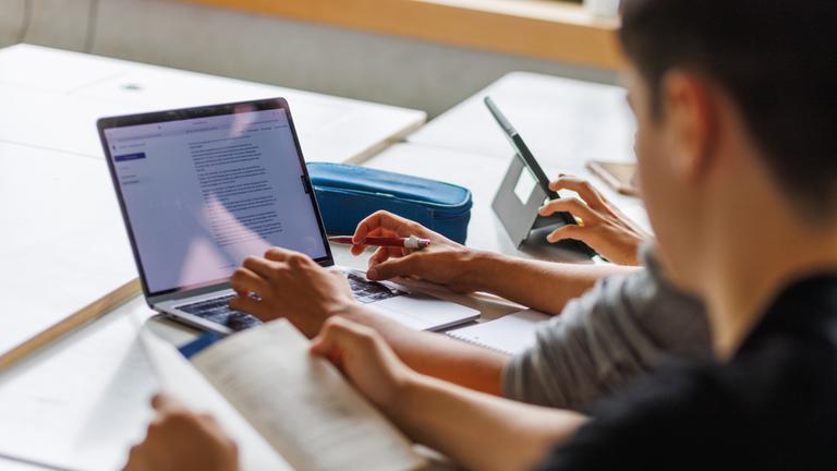 Schüler eines Gymnasiums in Karlsruhe (Baden-Württemberg) sitzen vor einem Computer und benutzen ein KI-Tool.