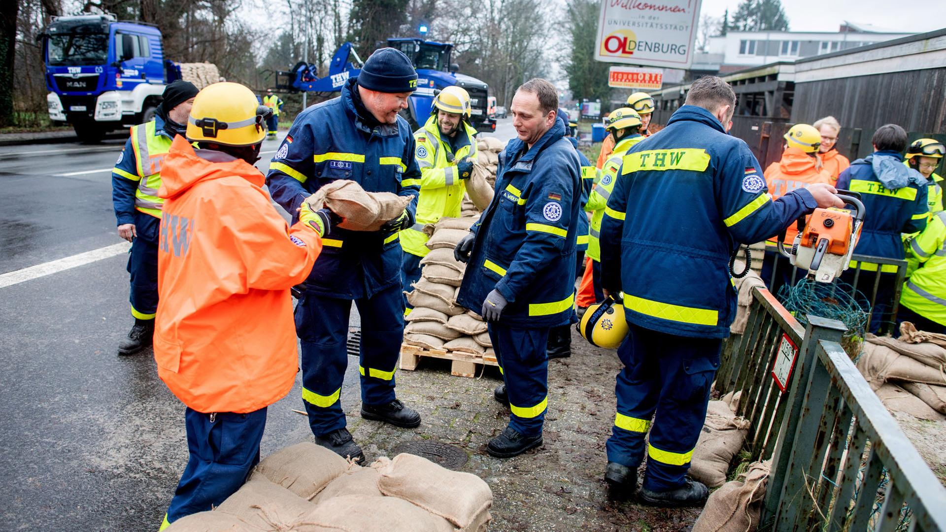  Einsatzkräfte des Technischen Hilfswerks (THW) sind im Einsatz, um ein Wohnhaus am Osternburger Kanal vor dem drohenden Hochwasser mit Sandsäcken zu sichern.  | dpa