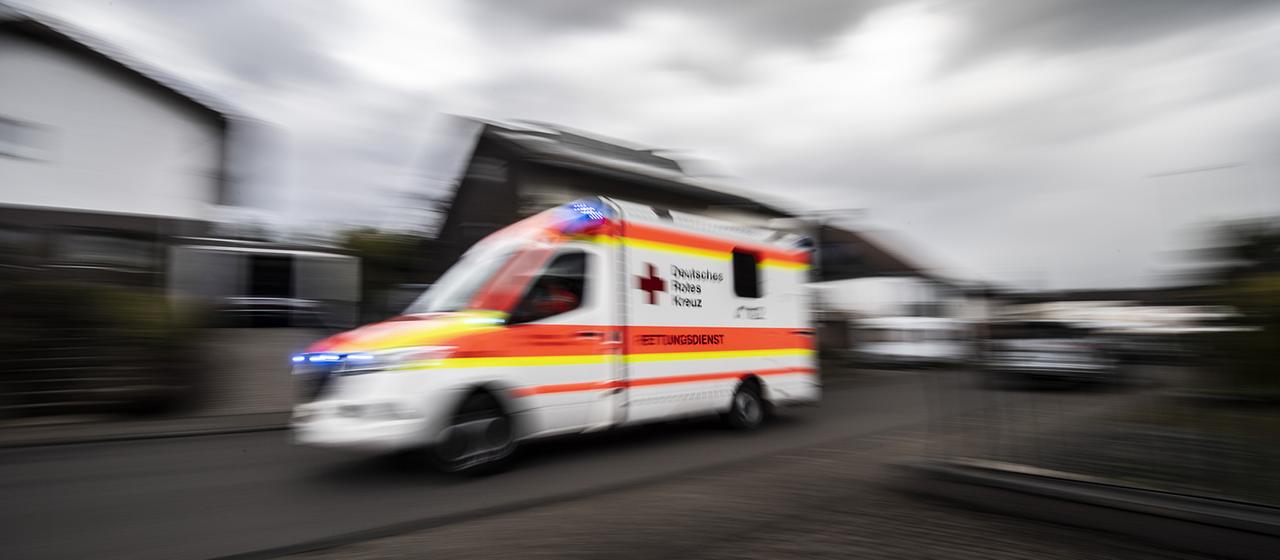 Ein Rettungswagen des Deutschen Roten Kreuzes fährt durch eine Straße.