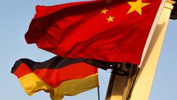 Eine chinesische Flagge weht vor einer deutschen Flagge