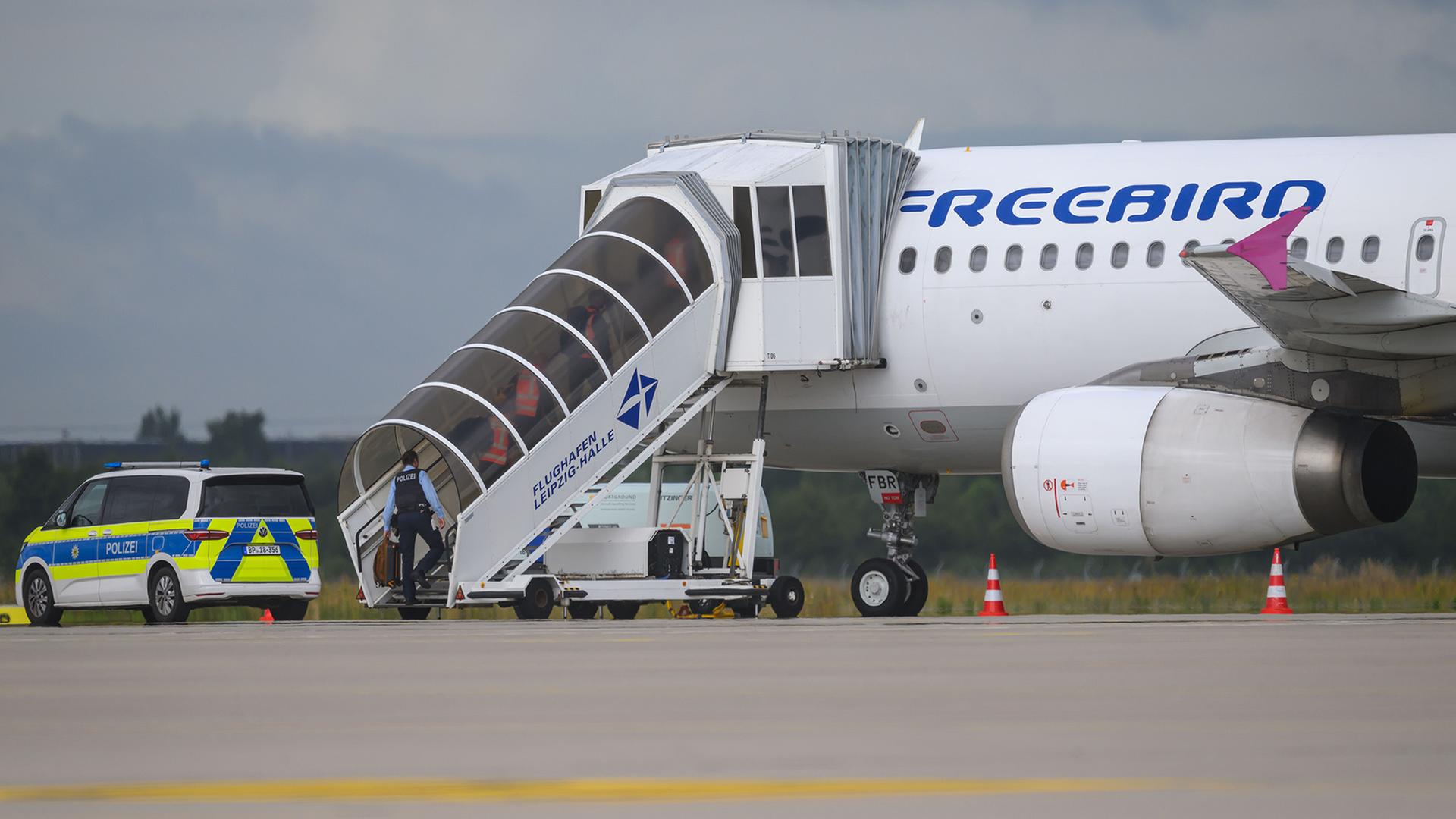Polizisten steigen in ein Flugzeug. | dpa