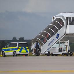 Polizisten steigen in ein Flugzeug.