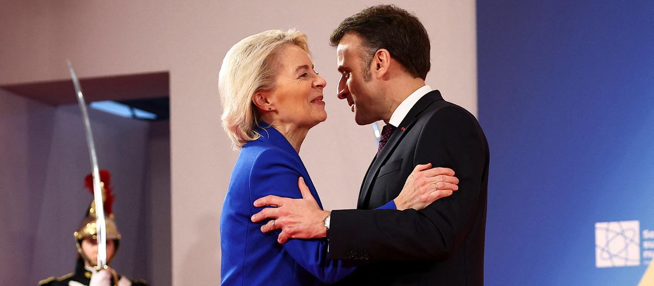 Ursula von der Leyen und Emmanuel Macron umarmen sich zur Begrüßung auf einem Gipfel in Paris.