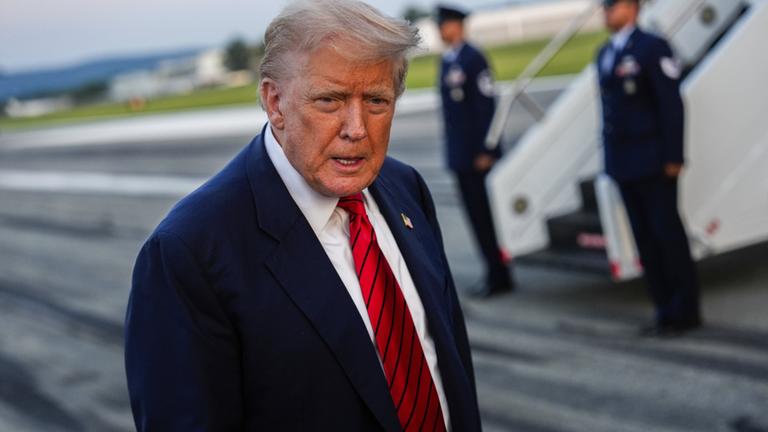 Donald Trump steht vor den Treppen der Air Force One.