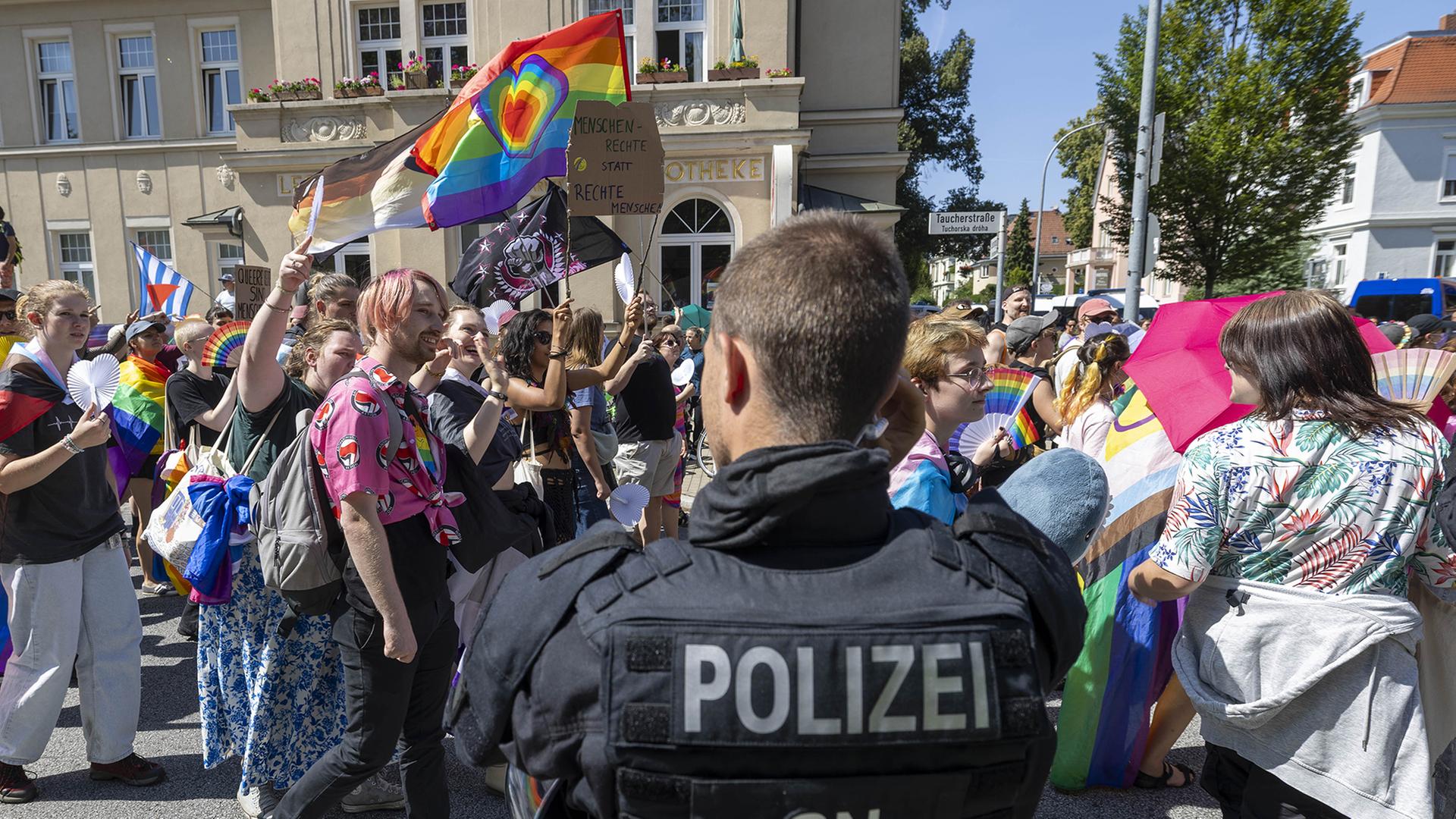 Ein Polizist beobachtet die Parade zum Christopher Street Day in Bautzen. (Archivbild: 10.08.2025) | dpa