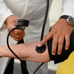 Ein Hausarzt misst in seiner Praxis in Stuttgart einer Patientin den Blutdruck