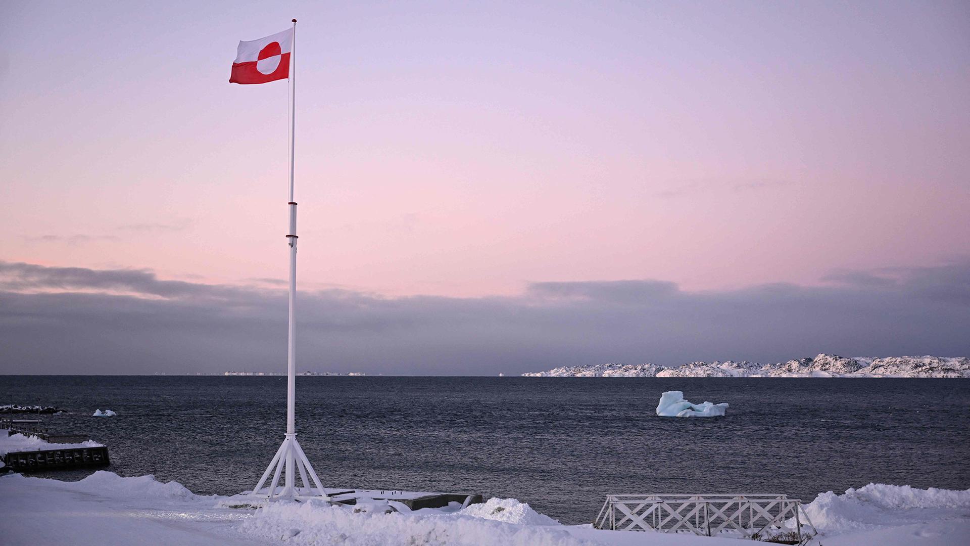 Die Flagge Grönlands flattert an einem Ufer im Wind. | AFP