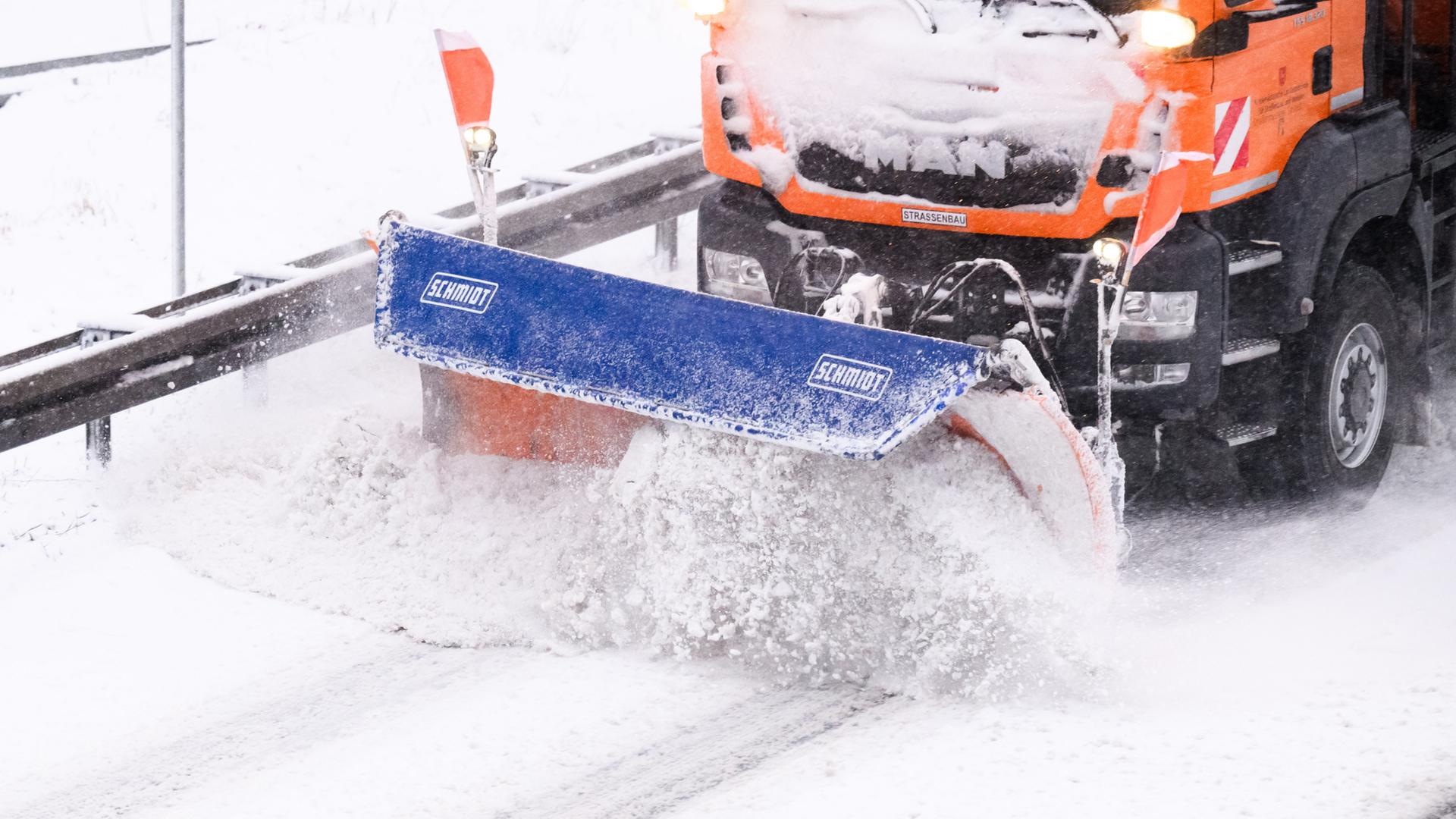 Ein Räumfahrzeug räumt eine schneebedeckte Straße | dpa