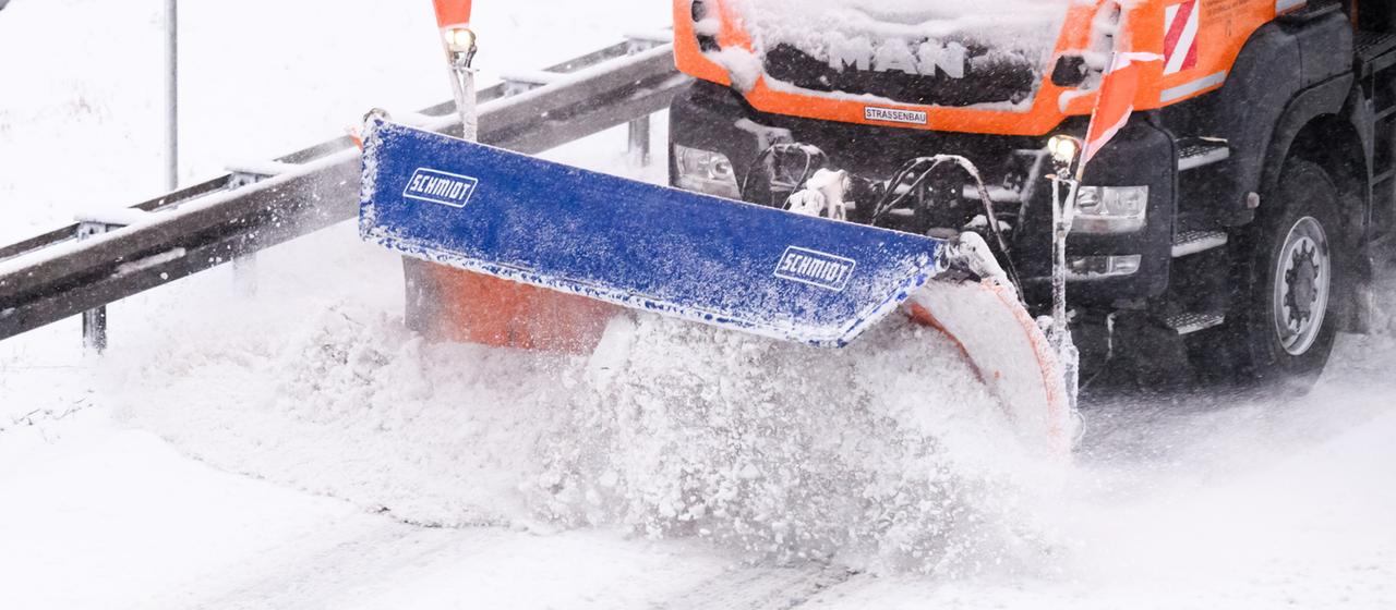 A snow-clearing vehicle clears a snow-covered road