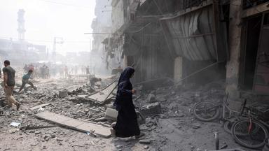 Menschen gehen durch Trümmer im südlichen Stadtteil al-Zeitoun in Gaza-Stadt. 