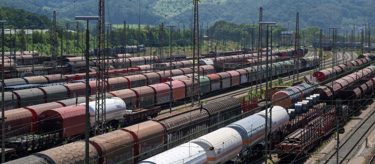 Mehrere Güterwaggons der Deutschen Bahn stehen an einem Bahnhof