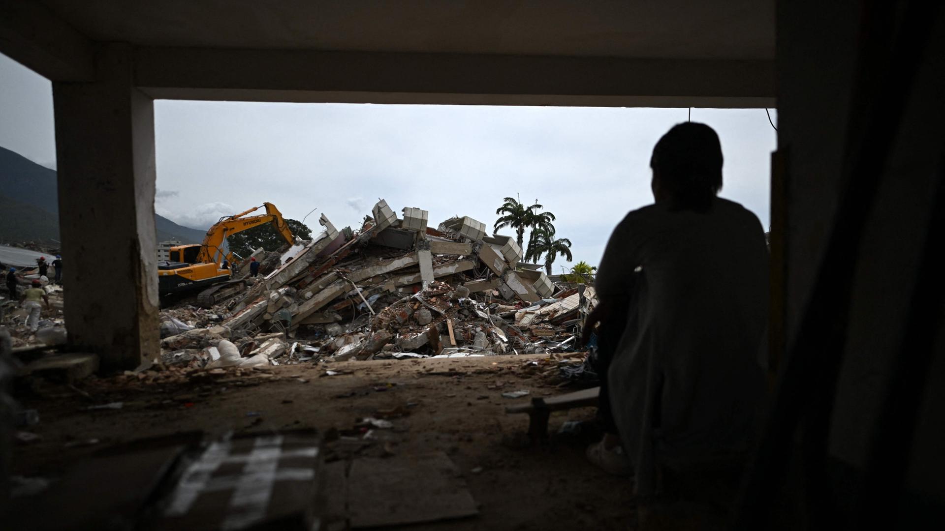 Eine Person schaut auf ein zerst�rtes Geb�ude. | AFP