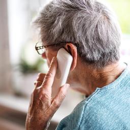 Eine Seniorin am Telefon.