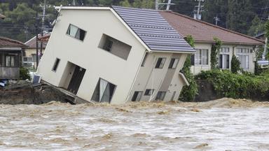 Ein Haus neigt sich, als ein angeschwollener Fluss den Boden in Suzu, Japan, nach heftigen Regenfällen unterspült.