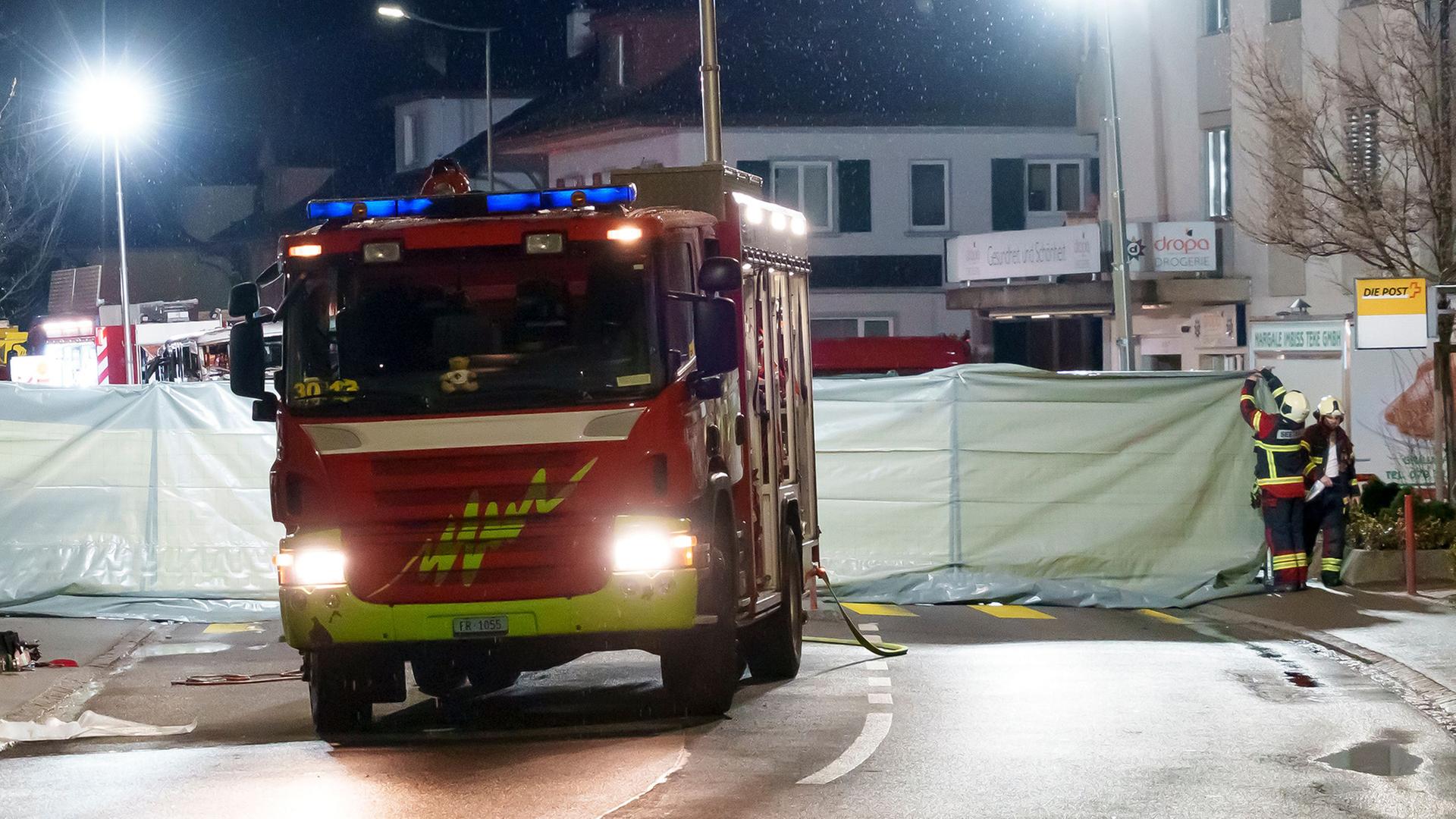 Feuerwehrleute und Polizisten errichten Absperrungen für einen Bereich, in dem ein Bus in Brand geraten ist. | Laurent Merlet/KEYSTONE/dpa