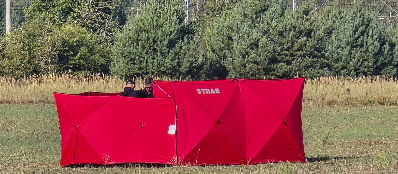 Feuerwehrleute sichern Teile einer beschädigten, von polnischen Behörden abgeschossenen Drohne auf einem Gelände in Czosnówka in der Nähe von Biala Podlaska.