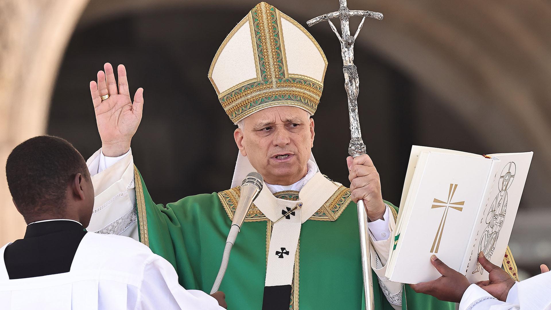 Papst Leo XIV. hält ein Kreuz in der Hand und spricht in ein Mikrofon. | dpa