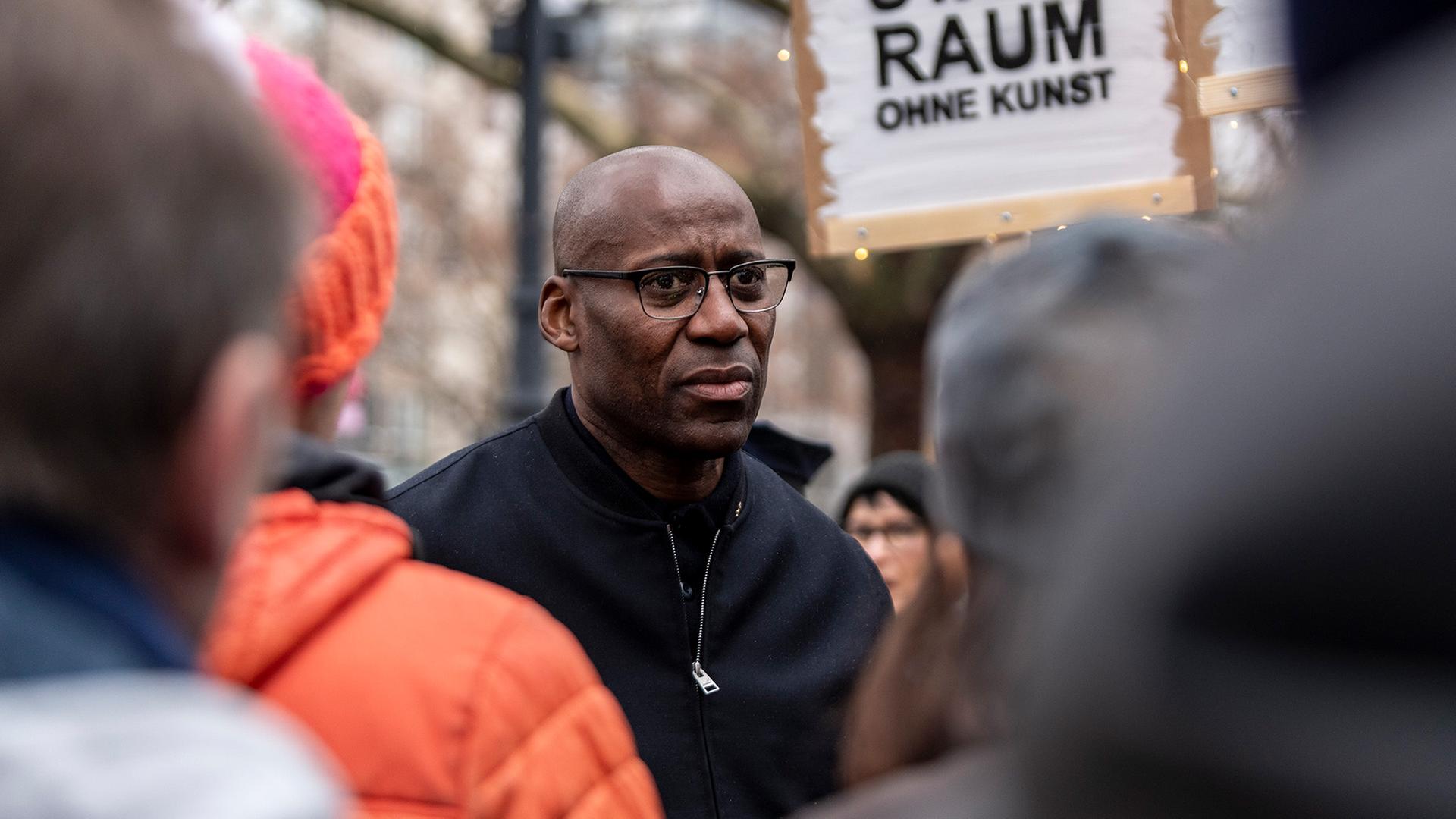 Archivbild: Joe Chialo, Kultursenator, beantwortet am 08.12.2024 Fragen von Demonstranten, die sich vor der Schaubhne in Berlin versammelt haben, um gegen die von der Regierung vorgeschlagenen drastischen Mittelkrzungen zu demonstrieren. (Quelle: Picture Alliance / Eventpress Jeremy Knowles) | Picture Alliance/Eventpress Jeremy Knowles