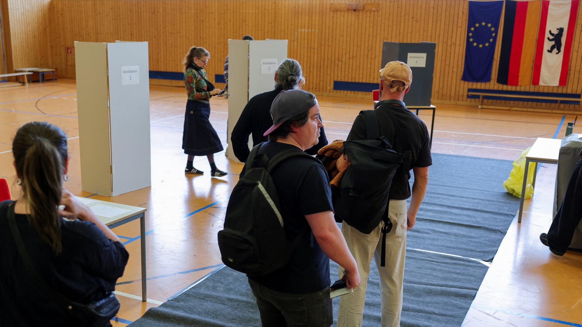 Menschen gehen in einem Wahllokal wählen. | REUTERS