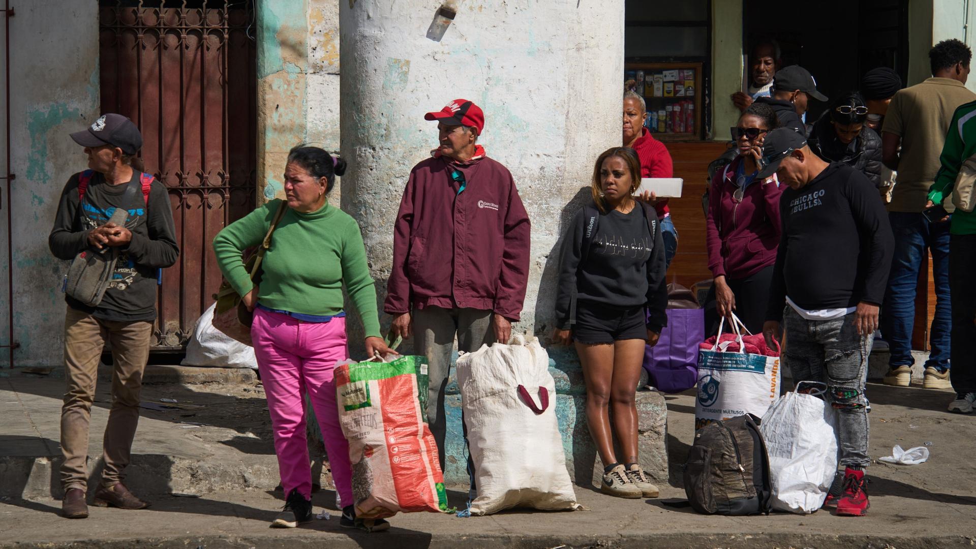 Menschen warten auf den Einstieg in ein Verkehrsmittel. | Ramon Espinosa/AP/dpa