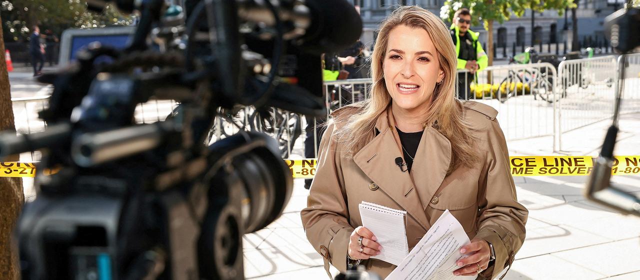 Betsy Klein spricht vor der Kamera in der Nähe des Weißen Hauses.