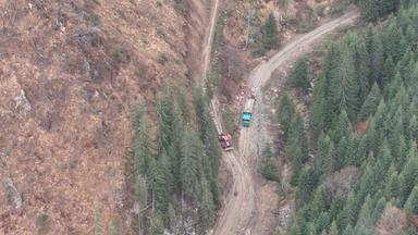 Drohnenaufnahme von LKWs auf einem Waldweg