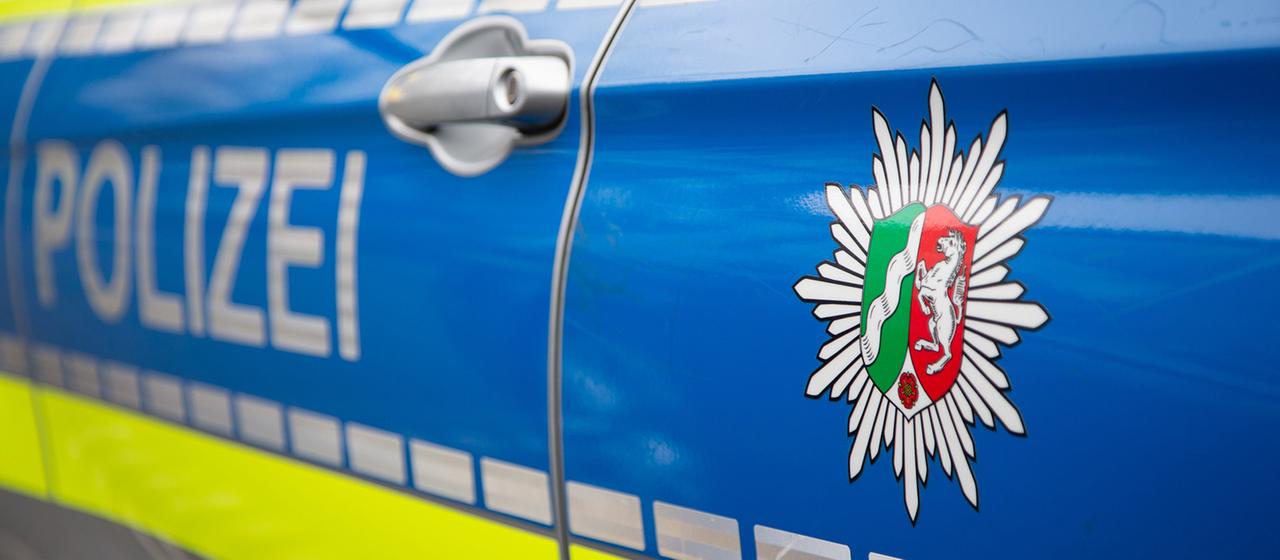 Blick auf ein Emblem der Polizei in NRW an einem Polizeiauto.