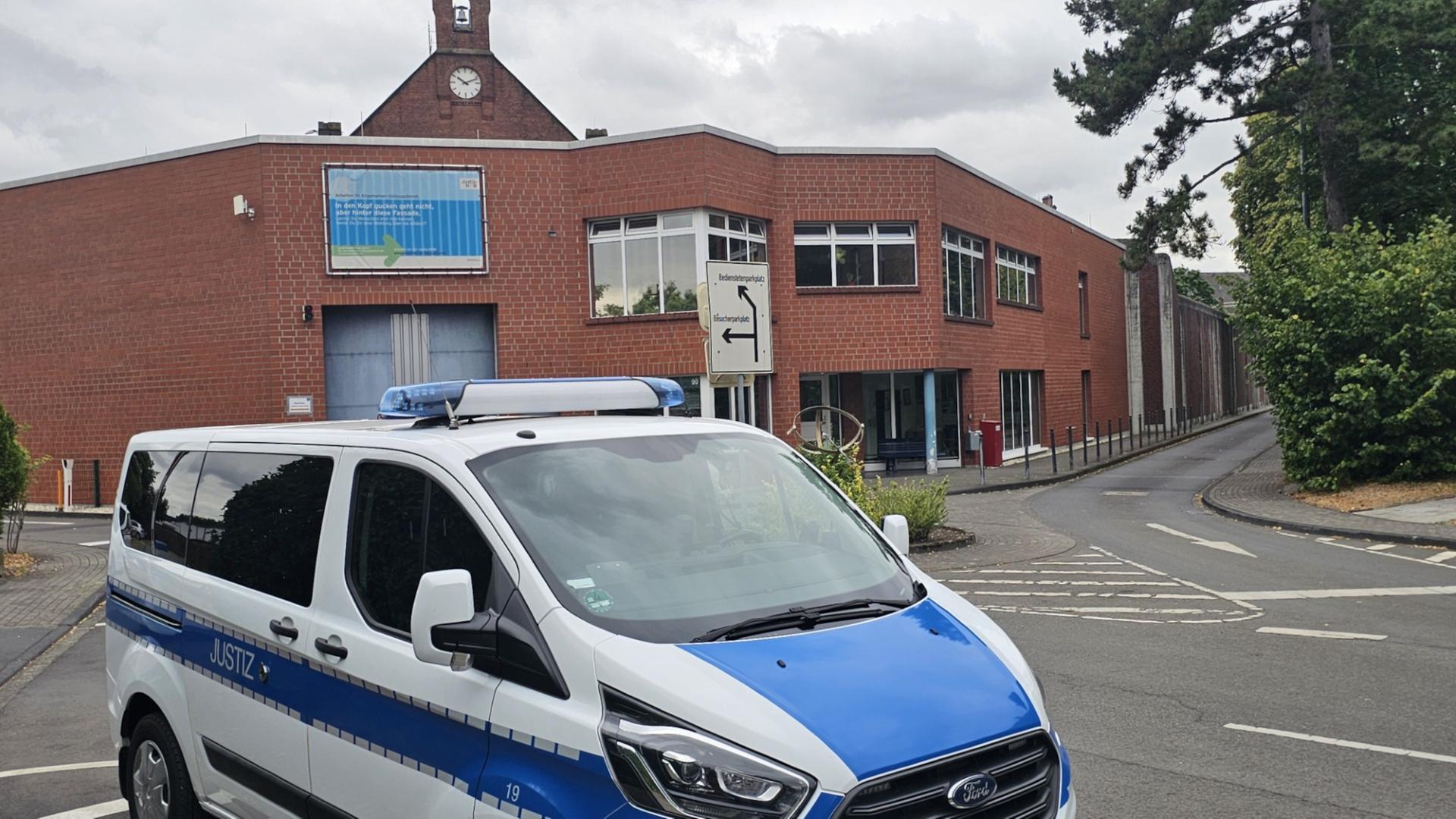 Ein Blau-weißes Spezialfahrzeug der Justizbehörde vor dem Gebäuder der JVA Siegburg. | WDR/Josef Kaiser