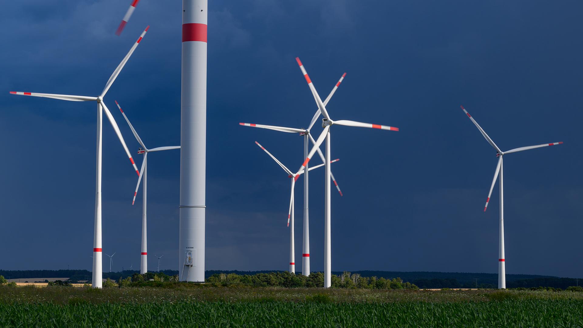 Mehrere Windkraftanlagen stehen sind vor dunklen Wolken zu sehen. | dpa