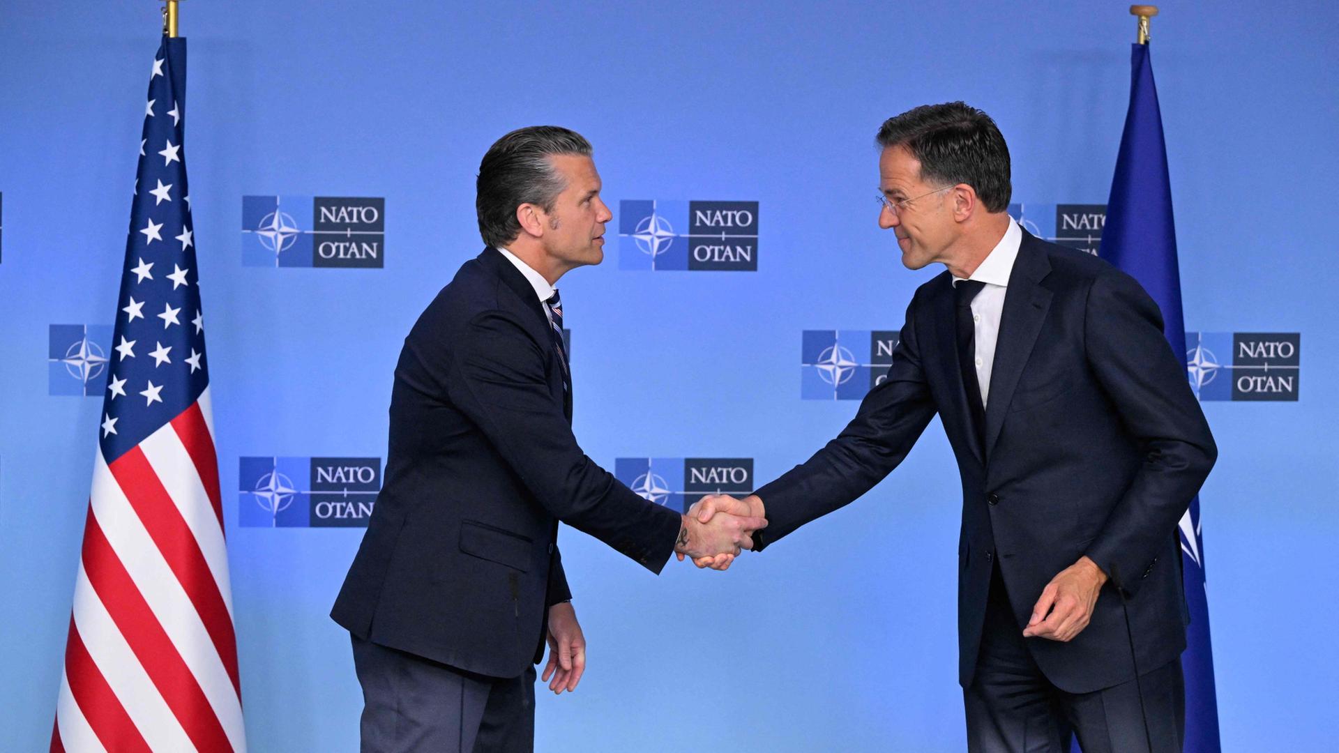 US-Verteidigungsminister Pete Hegseth und NATO-Generalsekretär Mark Rutte schütteln sich am Tag eines Treffens der NATO-Verteidigungsminister im Hauptquartier des Bündnisses in Brüssel die Hände. | AFP