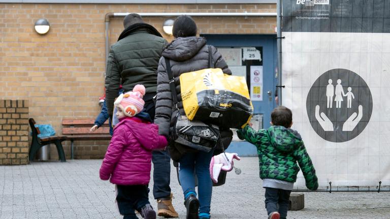 Eine geflüchtete Familie geht über das Gelände der Erstaufnahmeeinrichtung in Reinickendorf.