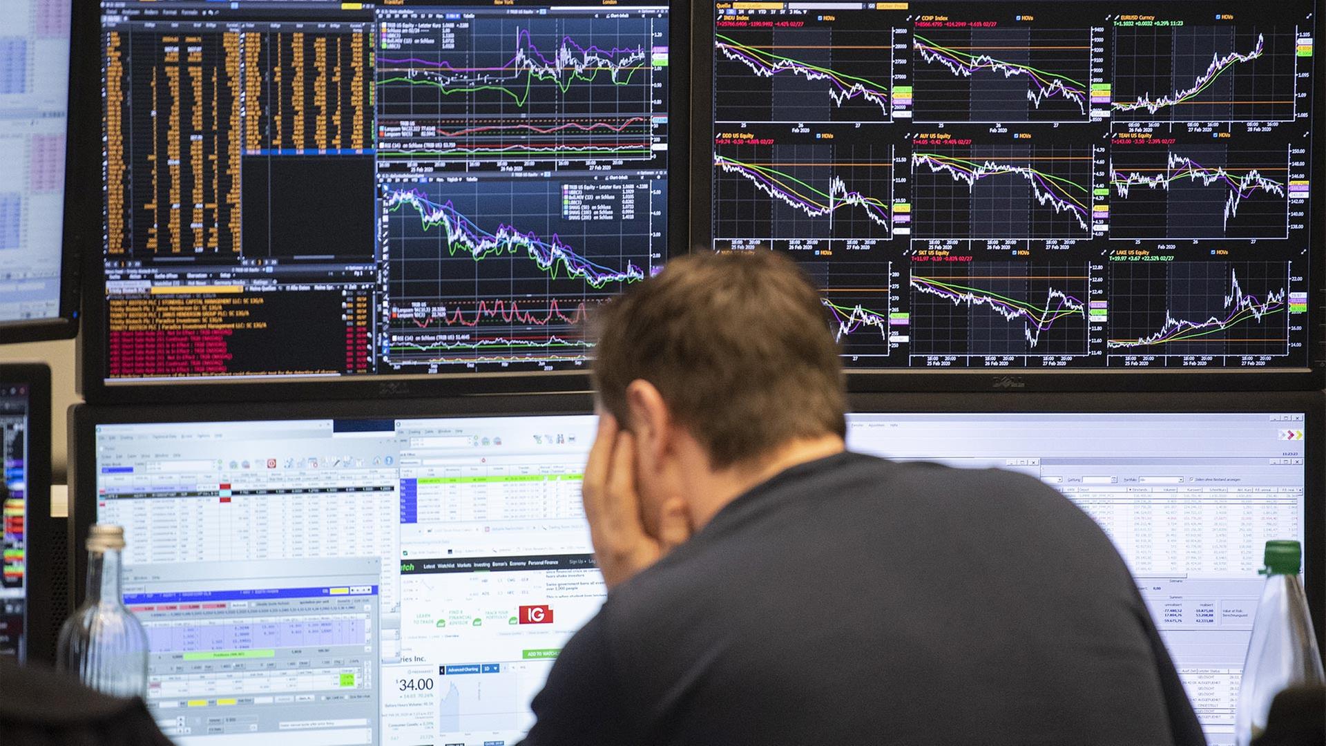 Ein Börsenhändler an der Börse Frankfurt blickt auf seine Monitore. | picture alliance/dpa