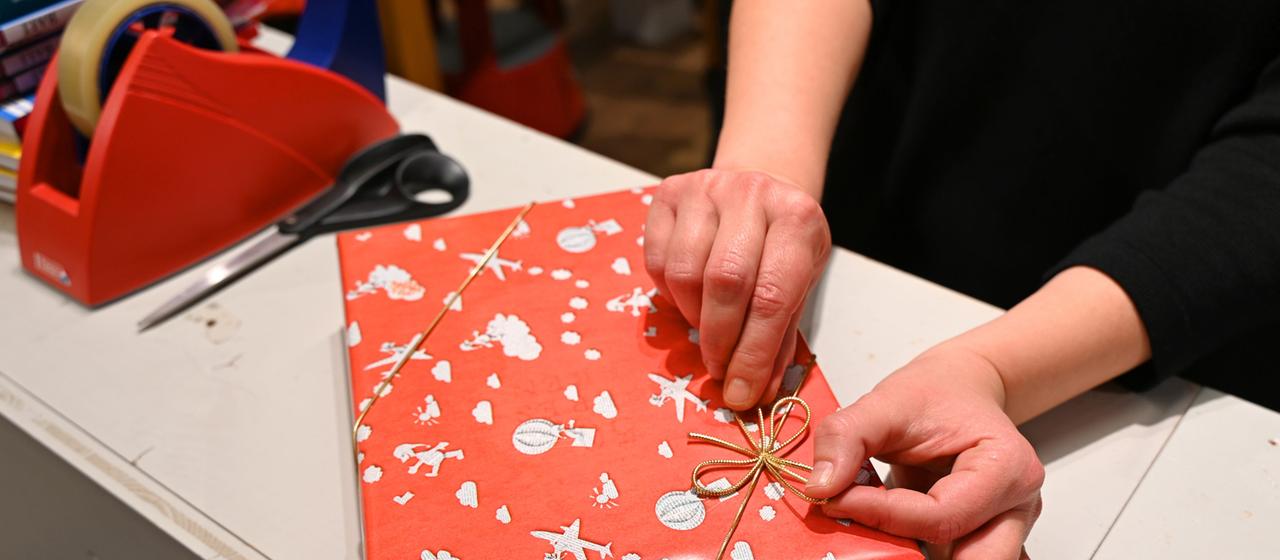 Eine Verkäuferin packt ein Geschenk ein