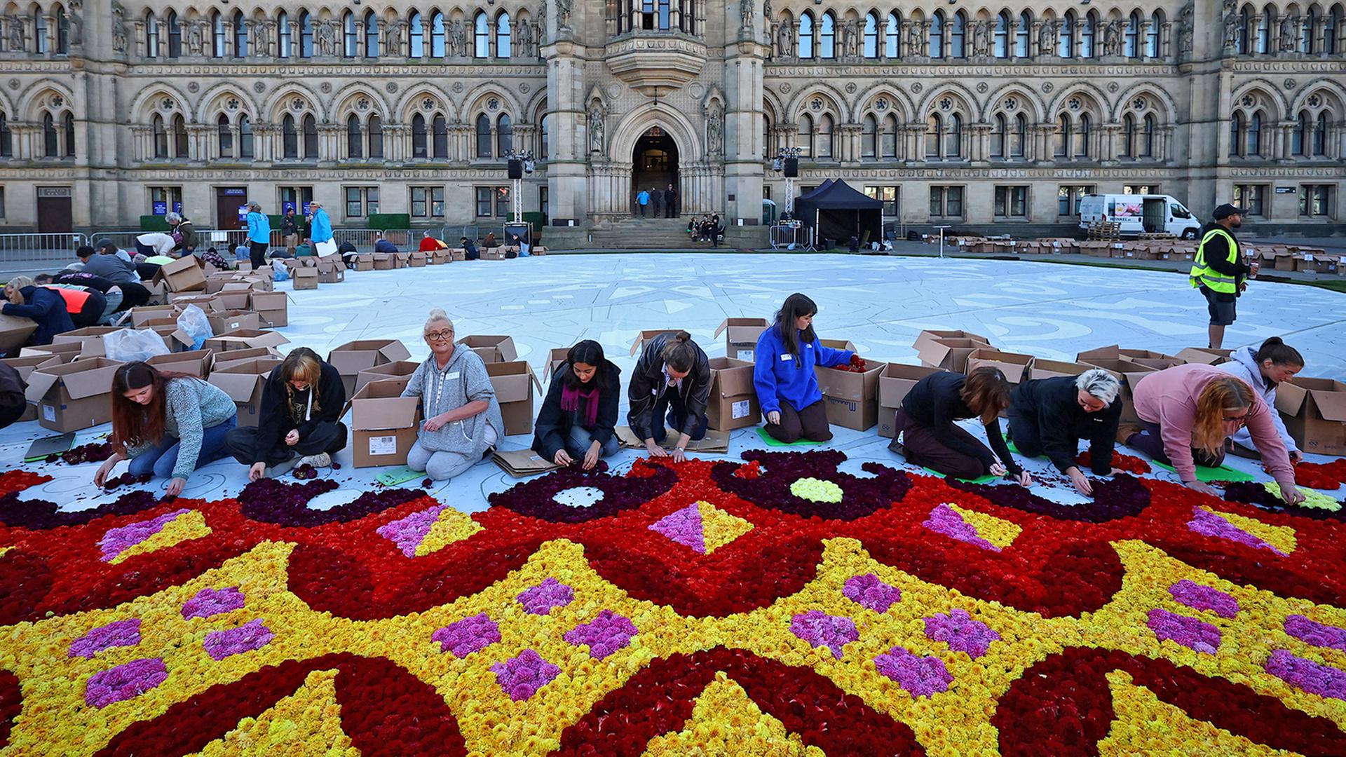 Freiwillige platzieren Blumen und BlÃ¼tenblÃ¤tter von mehr als 300.000 DahlienblÃ¼tenkÃ¶pfe in einem 29 Meter breiten Design in Bradford, GroÃbritannien. | REUTERS