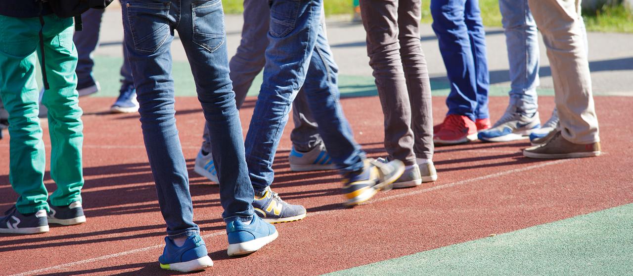 Eine Gruppe von Schülern steht zusammen auf einem Schulhof.