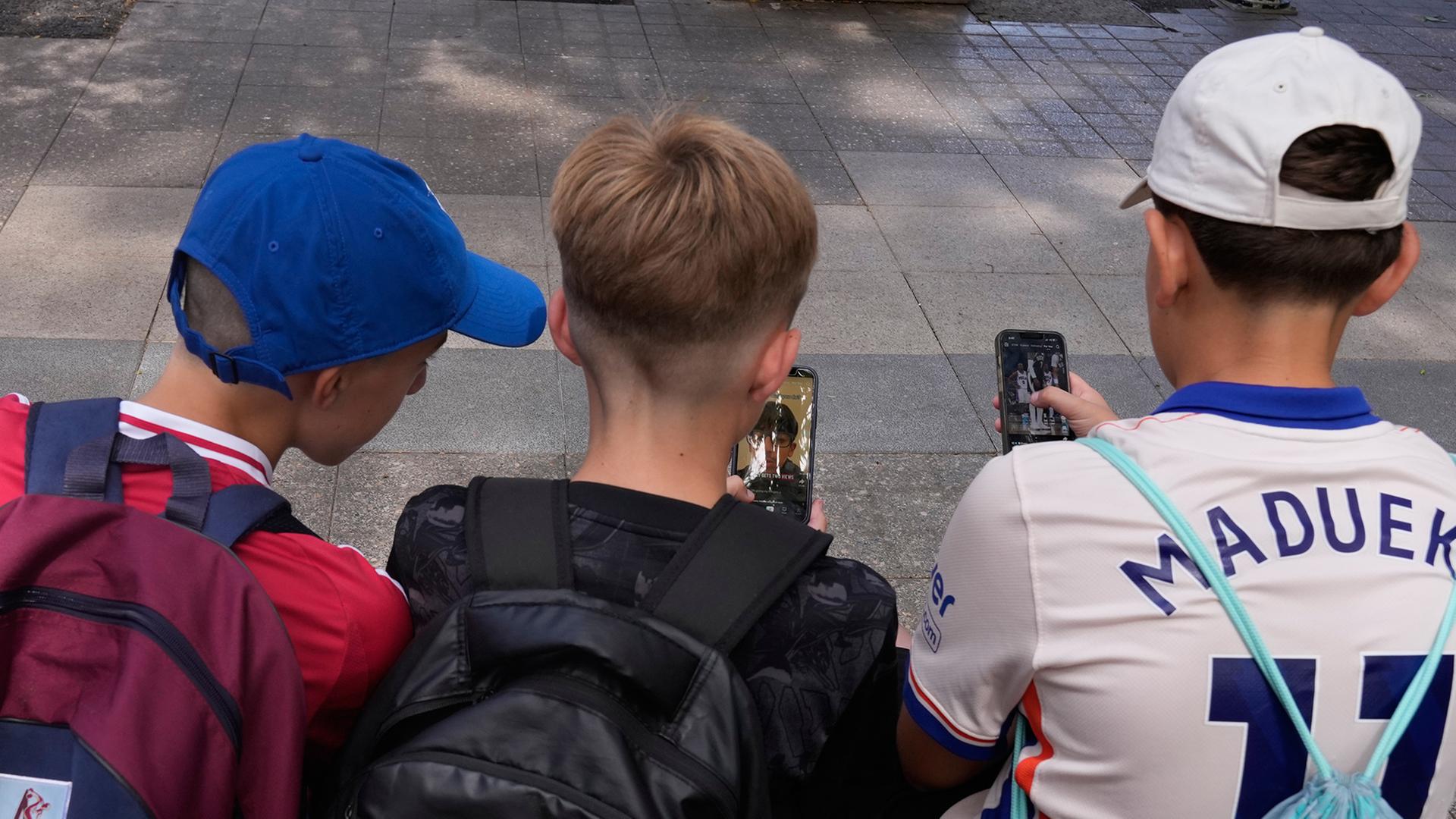 Jugendliche schauen Social-Media-Angebote auf ihren Smartphones | dpa